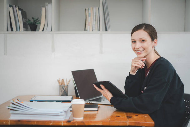 Kobieta biznesu za pomocą tabletu i laptopa do analizy raportu biznesowego w biurze - Zdjęcie, obraz