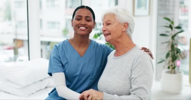 Lääketieteellinen, musta nainen sairaanhoitaja halaa vanhempaa potilasta, jolla on vamma ja tukea sairaalassa. Terveydenhuolto, luottamus ja lääketieteen ammattilainen klinikalla iäkkään naisen kanssa hoitoa varten. - Materiaali, video