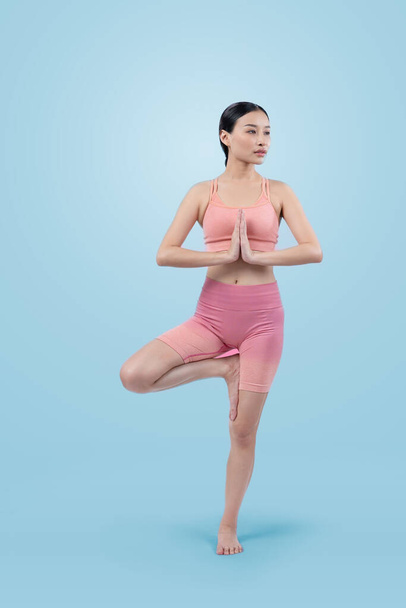 Mujer asiática en ropa deportiva haciendo ejercicio de yoga en pose de pie en la aptitud como su rutina de entrenamiento. Cuidado corporal saludable y meditación yoga estilo de vida en plena toma sobre fondo aislado. Vigoroso - Foto, Imagen