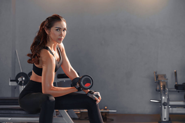 Fitness asiatische Frau macht Sport und hebt Hanteln Gewichte im Fitnessstudio. - Foto, Bild