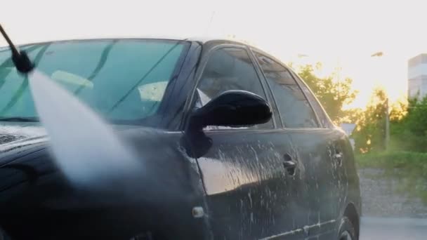 Lavado de lujo coche negro en el lavado de coches sin contacto. Limpieza de los detalles del coche. Lavado de coche sedán con espuma de autoservicio y agua de alta presión. Limpieza y orden en el entorno urbano - Metraje, vídeo