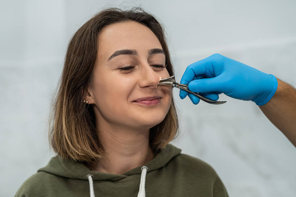 鼻の病気の少女患者と仕事をしながら耳鼻咽喉科医の肖像画。薬だ。鼻洞の検査 - 写真・画像