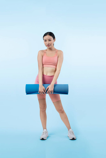 Fiatal vonzó ázsiai nő portré sportruházat testmozgó szőnyeg. Egészséges testmozgás és edzés rutin életmód koncepció. Stúdió lövés elszigetelt háttér. Élénk. - Fotó, kép