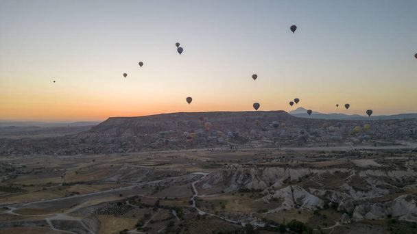 Hőlégballonok. Hőlégballonok repülnek a tündér kémények felett Cappadociában. Légi felvétel. Törökország turisztikai látványosságok - Fotó, kép