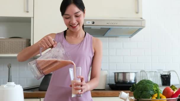 Mujer asiática preparando verduras fruta bebida mezclada para la piel y la salud después de hacer ejercicio para la salud en el hogar. dieta y concepto de comida saludable. - Metraje, vídeo