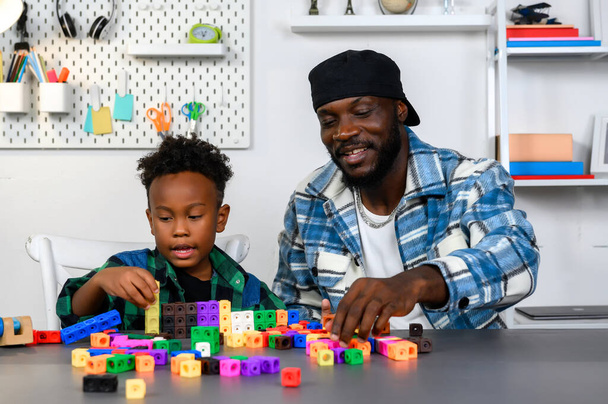 Loving Father Teaches and Plays with Son at Home for Learning and Education on Counting Cube in Math and Skill Development. Father Nurtures Child's Skills Through Play and Education Concept. - Photo, Image