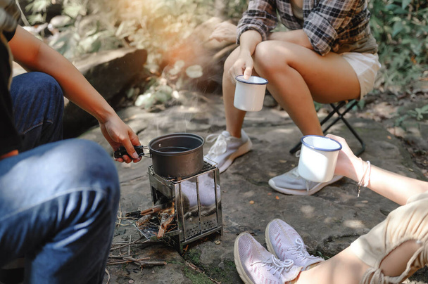 Close-up of Boiling Water with a Camp Stove of a Young People Trekking Group while Sitting Relaxed in the Rainforest and Campsite Drinking Coffee and Water. - Photo, Image