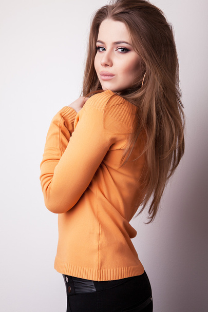 Young sensual & beauty model girl iin casual orange sweater pose in studio. - Фото, зображення