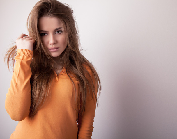 Young sensual & beauty model girl iin casual orange sweater pose in studio. - Fotografie, Obrázek