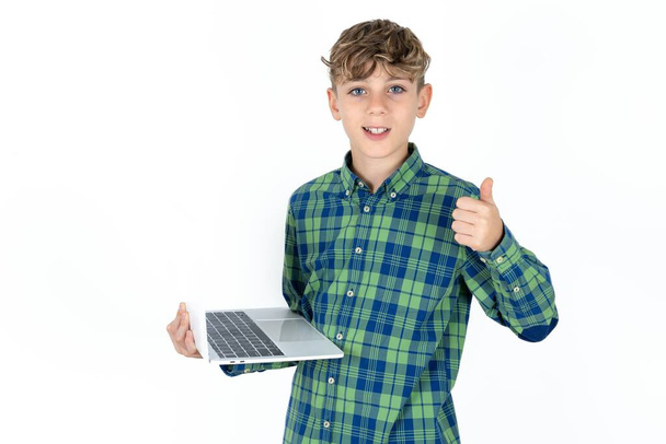 bello attraente bello teen ragazzo indossare plaid camicia su bianco fondo tenere netbook mano dito spettacolo pollice su - Foto, immagini