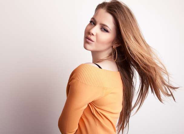 Young sensual & beauty model girl iin casual orange sweater pose in studio. - Zdjęcie, obraz