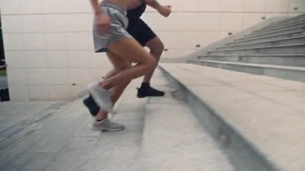Vágott felvétel férfi és nő kocog az emeleten edzés közben a szabadban - Felvétel, videó