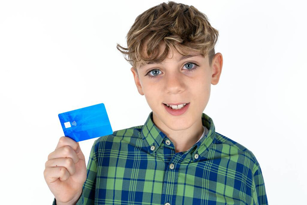 Close up photo of optimistic handsome caucasian teenager boy on white studio background hold card - Фото, зображення