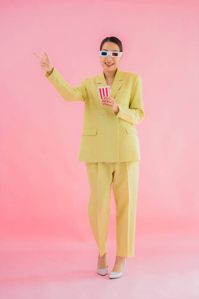 Portrait belle jeune femme asiatique avec des lunettes 3D et pop-corn prêt pour regarder le film sur fond de couleur - Photo, image