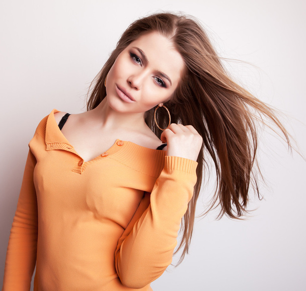 Young sensual & beauty model girl iin casual orange sweater pose in studio. - Fotó, kép