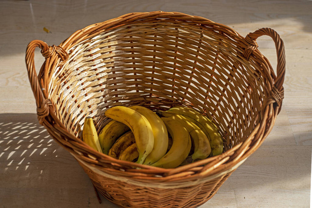 plátanos amarillos yacen en una cesta de ratán - Foto, imagen