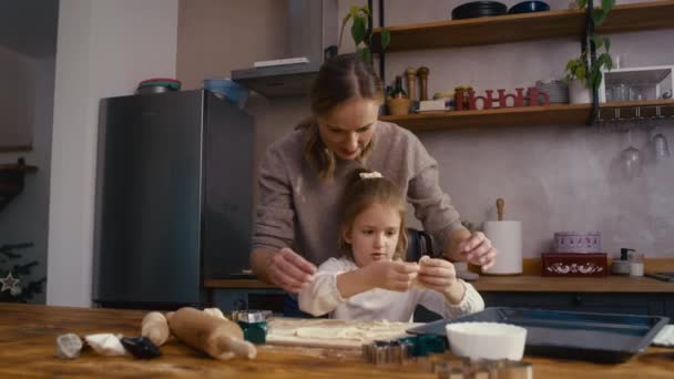 Biała kobieta z córką pieką ciasteczka w czasie świąt w kuchni. Nakręcony aparatem hel RED w rozdzielczości 8K.     - Materiał filmowy, wideo