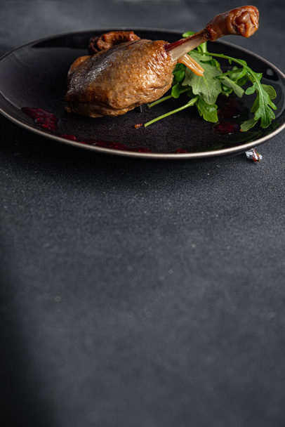 πάπια πόδι confit σάλτσα μούρου κρέας πουλερικών δεύτερο πιάτο νόστιμο φαγητό ορεκτικό γεύμα σνακ στο τραπέζι αντίγραφο χώρο τροφίμων φόντο ρουστίκ πάνω όψη - Φωτογραφία, εικόνα
