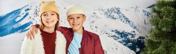 preteen αγόρι με το χέρι στον ώμο κορίτσι χαμογελώντας στην κάμερα, χειμωνιάτικη στολή, έννοια της μόδας, πανό - Φωτογραφία, εικόνα