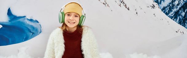 wesoła nastolatka dziewczyna w stylowym stroju z słuchawkami uśmiechnięta szczęśliwie do kamery, koncepcja mody, baner - Zdjęcie, obraz