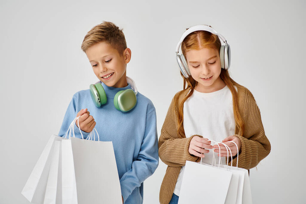 jolly little friends with headphones looking in their present bags, Black Friday, fashion concept - Photo, Image