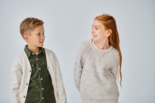 Веселые preadolescent мальчик и девочка в стильной повседневной одежде счастливо улыбаясь друг другу, мода - Фото, изображение