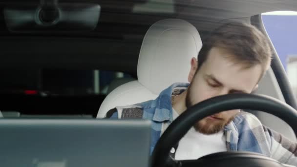 Ragazzo barbuto seduto al sedile del conducente in macchina mentre guardava lo specchio retrovisore prima del viaggio. Sicurezza di guida, trasporto, concetto di viaggio. Rallentatore - Filmati, video