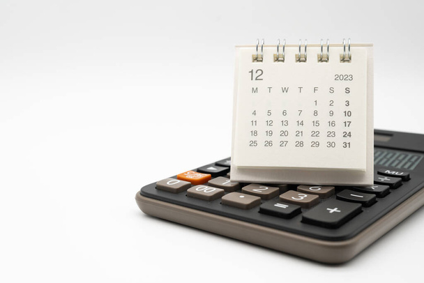 calculadora y calendario DEC 2023 sobre fondo blanco para el concepto de gestión de dinero y deuda. Cálculo económico antes de 2024. - Foto, imagen