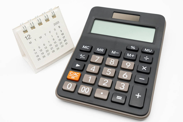 calculadora y calendario DEC 2023 sobre fondo blanco para el concepto de gestión de dinero y deuda. Cálculo económico antes de 2024. - Foto, imagen
