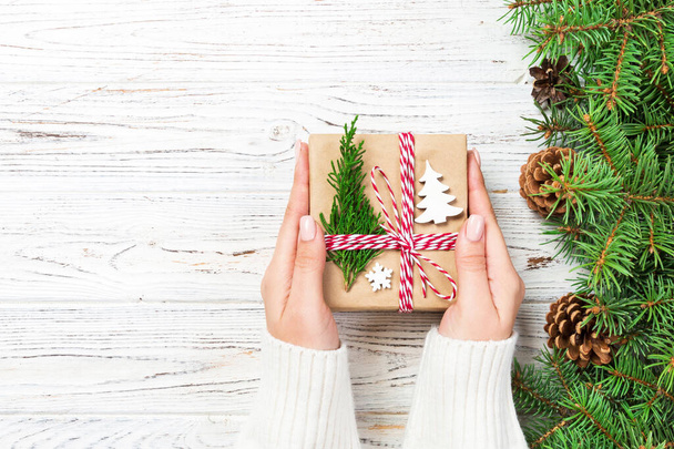 Caja de regalo de Navidad envuelta en papel reciclado, con lazo de cinta, con cinta sobre fondo rústico. Concepto de vacaciones
. - Foto, imagen