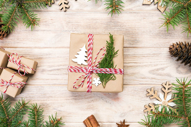 Sfondo natalizio con abete e scatola regalo su tavolo di legno. Vista dall'alto con spazio di copia per il tuo design
. - Foto, immagini