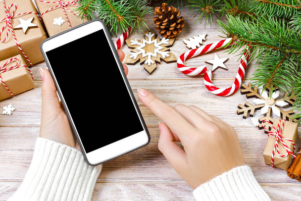 Női vevő teszi rendelés képernyőn a smartphone-val másol hely. Karácsonyi online vásárlás. Nő vásárol ajándékot karácsonyra. Téli üdülés értékesítés. - Fotó, kép