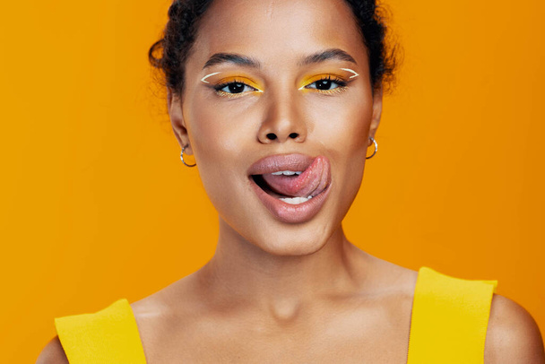 Γυναίκα κοσμετολογία έθνικ δέρμα μάτι δημιουργικό αντίγραφο στυλ κίτρινο καλλυντικά μαύρο πρόσωπο μοντέλο στούντιο ομορφιά πορτρέτο αφρικανικό χαμόγελο όμορφο ροζ χώρο πολύχρωμο μακιγιάζ μόδας - Φωτογραφία, εικόνα