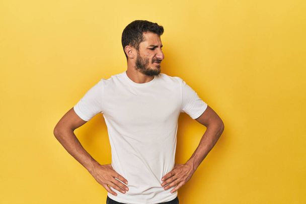Young Hispanic man on yellow background confused, feels doubtful and unsure. - Photo, Image