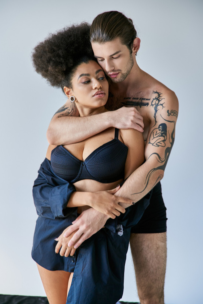 appealing young multiracial boyfriend and girlfriend in underwear hugging warmly, togetherness - Photo, Image