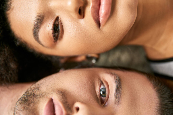 close up view of attractive sexy multicultural couple lying and looking straight at camera - Photo, Image