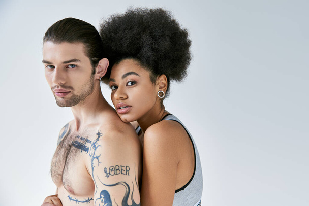mujer afroamericana de buen aspecto abrazando a su novio tatuado por detrás, sexy pareja - Foto, imagen