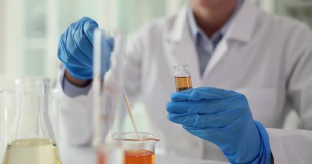 Le travailleur de laboratoire prélève un échantillon d'urine du patient dans une fiole à l'aide d'une pipette dans une clinique légère. Le travailleur médical vérifie l'urine pour les toxines. Travailler avec des navires fragiles - Séquence, vidéo