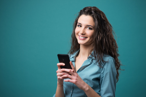 Lachende jonge vrouw met mobile - Foto, afbeelding