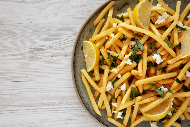 Homemade Greek Fries with Feta and Tzatziki on a Plate, top view. Flat lay, overhead, from above. Copy space. - Photo, Image