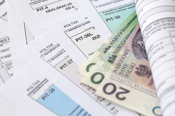 Dinheiro zloty polonês PLN em grande quantidade de PIT polonês, CIT e formas de imposto de IVA de perto. Contabilidade, burocracia e rotina dos contribuintes na Polónia - Foto, Imagem