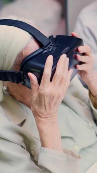 Top view video van een verbaasd oude vrouw met behulp van Virtual reality bril in een geriatrische - Video