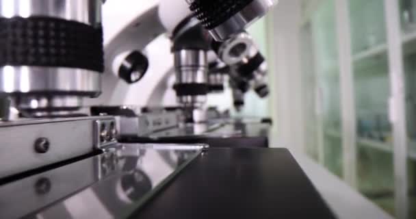 Microscopes put in row for laboratory researches in specialized clinic. Concept of instruments with various lenses for special tests in light office - Footage, Video