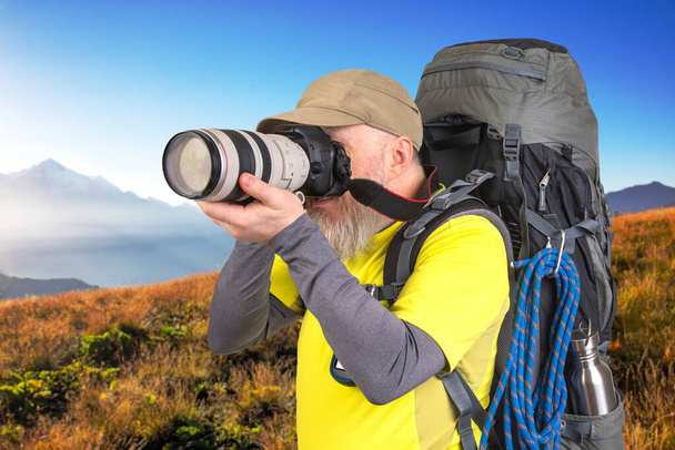 photographer traveler with a backpack photographs the beauty of nature on a journey - Photo, Image