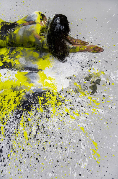 sexy nahá žena ve žluté, zelené, černé, bílé barvě, ležící dekorativní, elegantní na podlaze ateliéru. Tvůrčí, abstraktní expresivní malba těla, kopírovací prostor - Fotografie, Obrázek