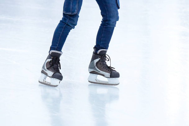piernas de un patinador en una pista de hielo. pasatiempos y deportes de invierno - Foto, Imagen