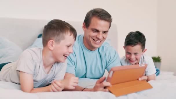 Apa, gyerekek és nevetni tabletta a hálószobában játékok, tanulási és olvasási könyv otthon. Happy, apa és fiú gyerekek nézni vicces rajzfilm együtt, streaming digitális multimédia vagy előfizetés. - Felvétel, videó
