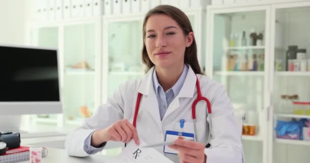Dokter die een doktersrecept heeft voor medicijnen in de kliniek. Voorgeschreven geneesmiddel en ziektekostenverzekering - Video