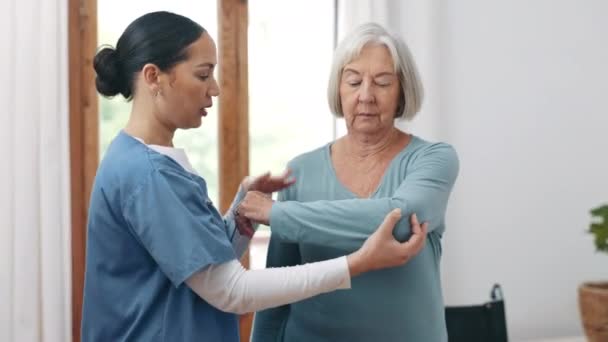 Nurse, patient and rehabilitation for injury in facility with examination for recovery. Senior woman, shoulder and pain in retirement by consultation with medical professional for care, help or trust. - Materiał filmowy, wideo