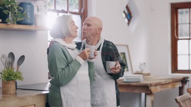 Kahvi, keskustelu ja vanhusten pari keittiössä kommunikointiin, puhumiseen ja sitoutumiseen yhdessä. Happy, keskustelu ja vanhempi mies ja nainen eläkkeellä puhuminen ja juominen cappuccino kotona - Materiaali, video